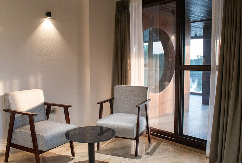 Cozy sitting area with armchairs and small table near balcony at Lakeside Manor