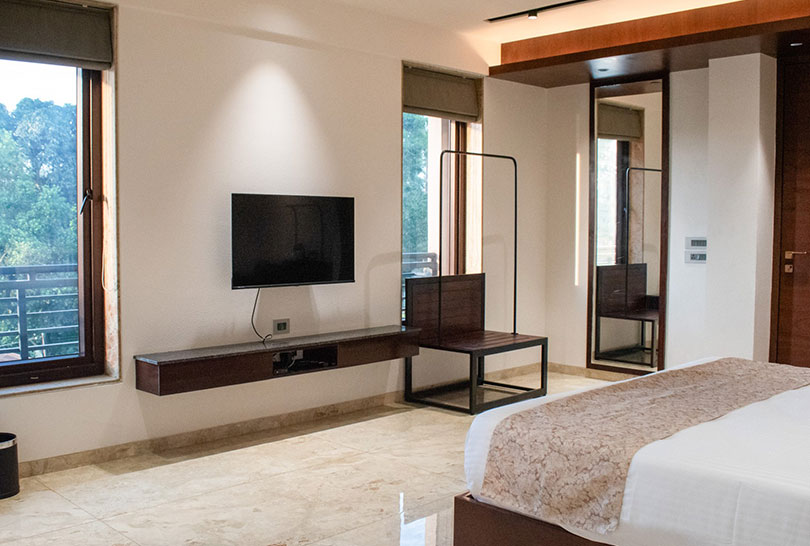 Bright guest room with flat‑screen TV and large windows at Lakeside Manor