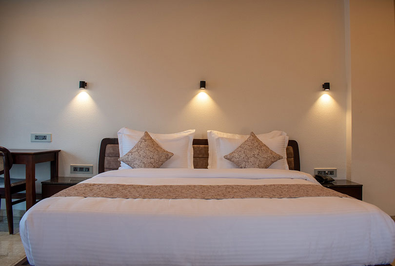 Comfy king‑sized bed with accent lighting in a Lakeside Manor room