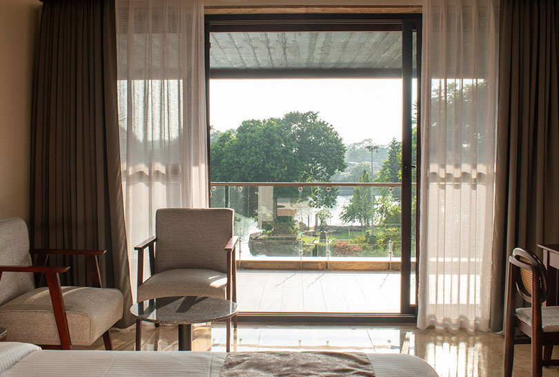 Balcony view of the lake and verdant gardens from a Lakeside Manor room