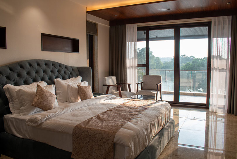 Luxurious suite with tufted headboard and panoramic balcony at Lakeside Manor