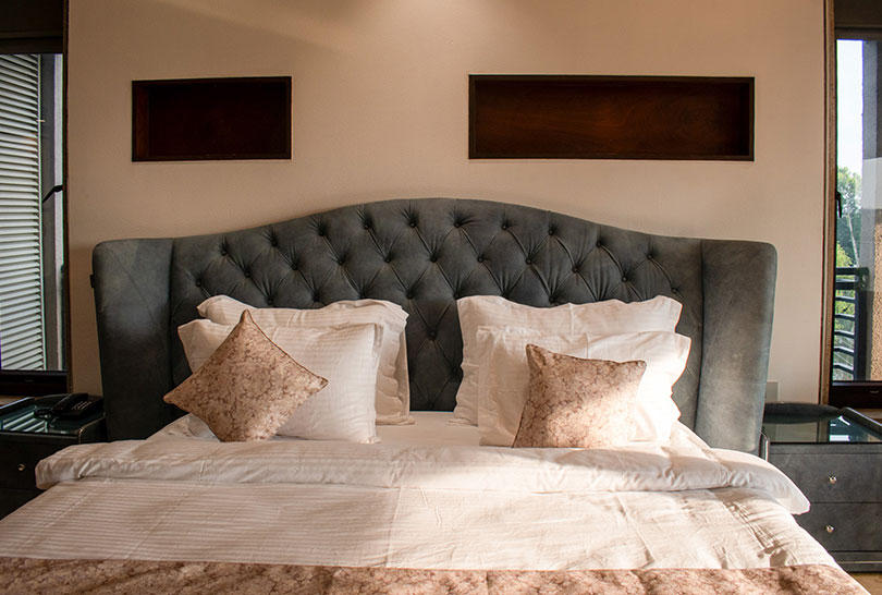 Close‑up of tufted headboard and soft pillows on a luxury bed at Lakeside Manor